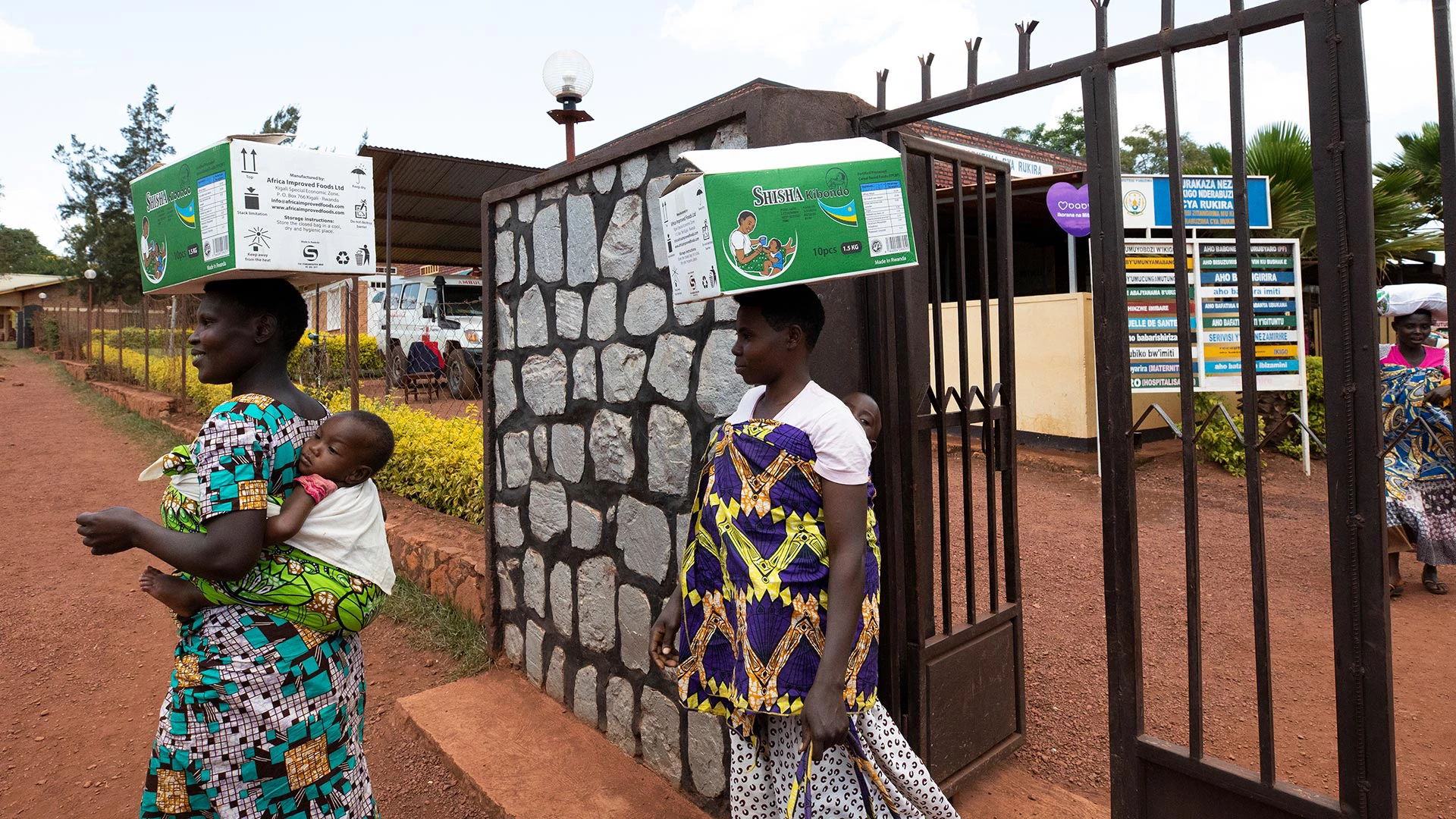 Solange Uwingeneye, (left) mother of twin babies, receives a box of fortified blended food for her malnourished children at the Rukina Health Center in Rikina Village, Rwanda on March 22, 2019. Photo © Dominic Chavez/International Finance Corporation