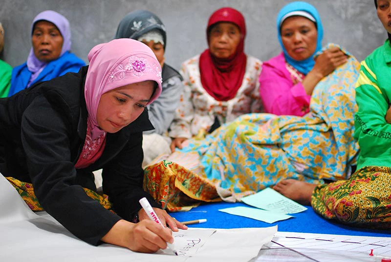 Women involved in community meeting to discuss village reconstruction.